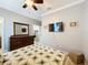 Bedroom featuring a wood dresser with mirror, wall mounted TV, doorway to another room, and carpeted floor at 1374 Zeek Ridge St, Clermont, FL 34715