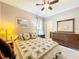 Bedroom featuring a ceiling fan, wood dresser, side tables with lamps, carpeted floors, and patterned bedding at 1374 Zeek Ridge St, Clermont, FL 34715