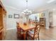 Elegant dining area with a wooden table, chandelier, and view of the adjacent office space at 1374 Zeek Ridge St, Clermont, FL 34715