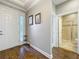 An open foyer with wood floors, coat rack, and a view into a full bathroom at 1374 Zeek Ridge St, Clermont, FL 34715