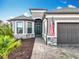 Close up on a stucco single Gathering home with a paver driveway and tropical landscaping at 1374 Zeek Ridge St, Clermont, FL 34715