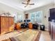 Functional home office with two desks, ample natural light, and wooden cabinets for storage at 1374 Zeek Ridge St, Clermont, FL 34715