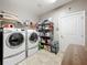 A laundry room with washer, dryer, wire shelving, and tiled flooring at 1374 Zeek Ridge St, Clermont, FL 34715