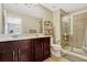 Bathroom featuring a double vanity, mirror, toilet, and a glass-enclosed shower with tiled walls at 1558 Downy Birch Ln, Longwood, FL 32750