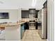 Kitchen featuring stainless steel appliances, dark cabinetry, and a breakfast bar at 1558 Downy Birch Ln, Longwood, FL 32750