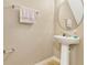 Simple powder room featuring a pedestal sink, oval mirror, and neutral color scheme at 1558 Downy Birch Ln, Longwood, FL 32750