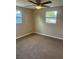 Bedroom with a ceiling fan, two windows, and neutral carpeting at 1583 Montgomery Ave, Holly Hill, FL 32117