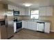 Modern kitchen featuring stainless steel appliances, white cabinets, and a granite countertop at 1583 Montgomery Ave, Holly Hill, FL 32117