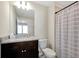 Bathroom with a modern vanity, granite countertop, and a shower with a curtain at 16207 Trinidad Way, Clermont, FL 34714