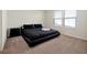 Sleek bedroom with a black bed, black furniture, and natural light from the windows at 16207 Trinidad Way, Clermont, FL 34714