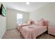 Charming bedroom with twin beds, pink bedding, and natural light from the window at 16207 Trinidad Way, Clermont, FL 34714