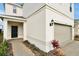 Home's entry with a black front door, beige walls, and dark lamp and some decorative foliage at 16207 Trinidad Way, Clermont, FL 34714