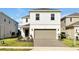 Charming two-story home featuring a neutral color palette, attached garage, and a well-manicured front yard at 16207 Trinidad Way, Clermont, FL 34714