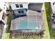 Aerial view of a screened-in pool with clear water and a well-maintained deck, surrounded by lush landscaping at 16207 Trinidad Way, Clermont, FL 34714