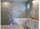 Modern bathroom featuring a freestanding tub, tile surround, and white vanity at 16880 Muskgrass Dr, Winter Garden, FL 34787