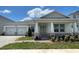 Charming single-story home featuring a two-car garage, stone accents, and a welcoming front porch at 16880 Muskgrass Dr, Winter Garden, FL 34787