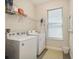 Bright laundry room featuring a washer, dryer, overhead shelf and window at 17858 Adrift Rd, Winter Garden, FL 34787