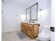 Bathroom featuring a wooden double vanity with two framed mirrors and tile flooring at 181 N Phelps Ave, Winter Park, FL 32789