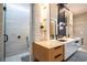 Modern bathroom featuring double vanity with unique mirrors, glass shower, and neutral colored tile at 181 N Phelps Ave, Winter Park, FL 32789