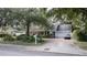 Beautiful home exterior featuring mature trees, manicured landscaping, and a two-car garage at 181 N Phelps Ave, Winter Park, FL 32789