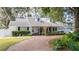 Charming home featuring a circular brick driveway, manicured landscaping, and a bright white exterior at 181 N Phelps Ave, Winter Park, FL 32789