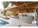 Outdoor kitchen featuring a ceiling fan, built-in grill, countertop seating, and a pool at 181 N Phelps Ave, Winter Park, FL 32789