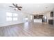 Open concept living room with wood floors, ceiling fan, and sliding glass doors to the backyard at 1920 Partin Terrace Rd, Kissimmee, FL 34744