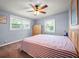 Bedroom with blue walls, carpet, two windows and a wood ceiling fan at 198 Benjamin Dr, Ormond Beach, FL 32176