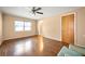 This bedroom features hardwood floors, a ceiling fan, and a large window with lots of light at 198 Benjamin Dr, Ormond Beach, FL 32176