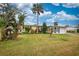 Landscaped front yard featuring a well-maintained lawn and tropical trees at 198 Benjamin Dr, Ormond Beach, FL 32176