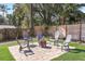 Backyard firepit area with chairs, pavers, manicured lawn and fenced perimeter at 203 E Sweetwater Creek Dr, Longwood, FL 32779