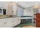 Bathroom featuring dual sinks, and a tub surrounded by green tile at 203 E Sweetwater Creek Dr, Longwood, FL 32779