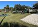 Grassy recreation area featuring a volleyball court, playground, and picnic tables in a well-maintained setting at 203 E Sweetwater Creek Dr, Longwood, FL 32779