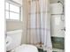 Bright shower with a neutral shower curtain, white tile, and chrome fixtures at 203 E Sweetwater Creek Dr, Longwood, FL 32779