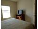 Bedroom featuring a dresser with a TV on top and a sunlit window at 2903 Edenshire Way # 108, Kissimmee, FL 34746