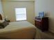 Bedroom featuring a large window and a wooden dresser with a TV on top at 2903 Edenshire Way # 108, Kissimmee, FL 34746