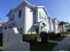 Townhouse exterior with light blue siding, dark shutters, and tidy landscaping along the sidewalk at 2903 Edenshire Way # 108, Kissimmee, FL 34746