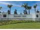 Community entrance to Harmony West featuring a stone base, stucco walls, and palm tree landscaping at 2987 Brie Hammock Bnd, St Cloud, FL 34773