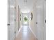 Well-lit hallway with neutral walls, tile flooring, and white doors enhancing the modern design at 2987 Brie Hammock Bnd, St Cloud, FL 34773