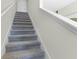 Carpeted staircase leading to the upper level, featuring a classic white handrail at 2987 Brie Hammock Bnd, St Cloud, FL 34773