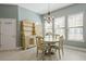 Bright dining area with a wooden table set, chandelier, and hutch, illuminated by natural light from three windows at 3321 Messina Dr, Lake Mary, FL 32746