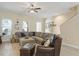 Comfortable living room featuring a sectional sofa, leather chair and ottoman, ceiling fan, and large windows at 3321 Messina Dr, Lake Mary, FL 32746