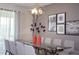 Stylish dining room featuring a modern chandelier, glass-top table, and tasteful wall art at 351 Ocean Course Ave, Davenport, FL 33896