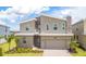 Modern two-story home featuring stone accents, a two-car garage, and a well-maintained front lawn at 351 Ocean Course Ave, Davenport, FL 33896