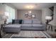 An inviting living room with a gray sectional sofa, stylish lamps, and geometric rug at 351 Ocean Course Ave, Davenport, FL 33896