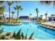 Community pool area with lush tropical landscaping, Tiki hut, and beach chairs at 351 Ocean Course Ave, Davenport, FL 33896