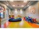 Colorful ' playroom with a large beanbag, tables, chairs, and lots of natural light at 351 Ocean Course Ave, Davenport, FL 33896