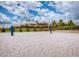 Sandy outdoor volleyball court with net and lush green landscaping in the background at 351 Ocean Course Ave, Davenport, FL 33896