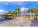 Spacious paved backyard featuring a pergola with outdoor seating, fire pit, and lush tropical landscaping at 352 Radisson Pl, Oviedo, FL 32765