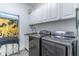 Modern laundry room with front loading washer and dryer, white cabinets, and sink at 352 Radisson Pl, Oviedo, FL 32765